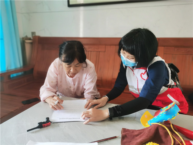 區(qū)人大機(jī)關(guān)黨員志愿者在指導(dǎo)居民填寫調(diào)查問(wèn)卷.jpg