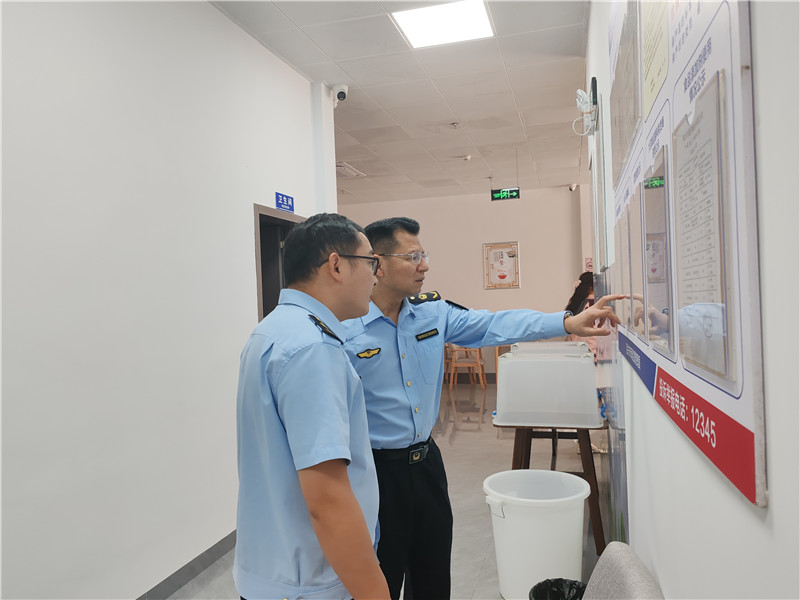 執(zhí)法人員檢查食品安全信息公示欄.jpg